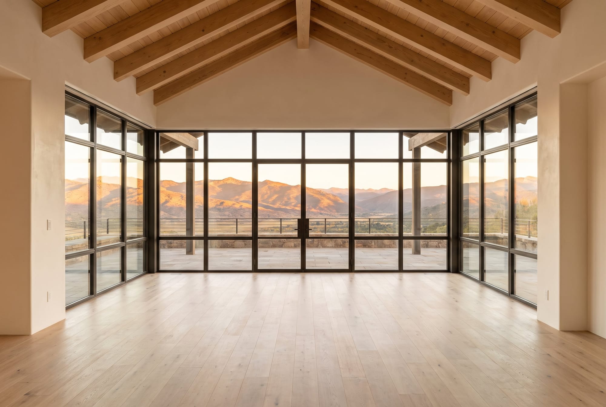 Great room with floor-to-ceiling glass on the west wall framing a mountain range, a detail a luxury listing description should name