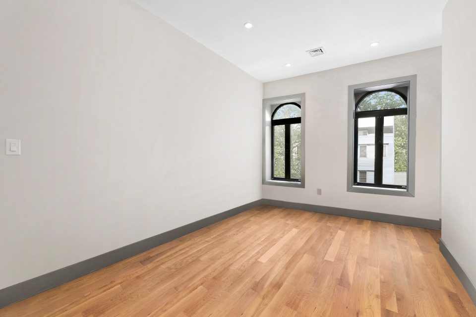 Empty bedroom before virtual staging, with arched windows