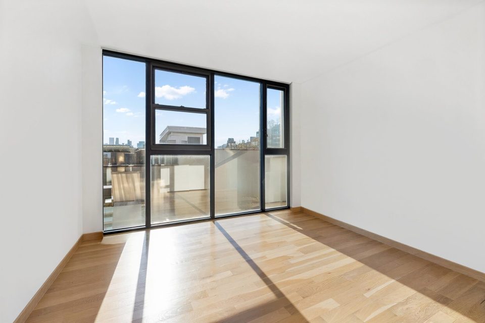 Empty bedroom before virtual staging, with floor-to-ceiling windows