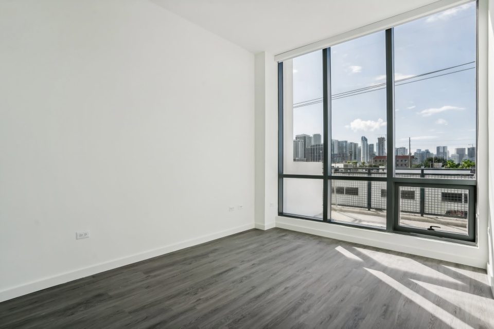Empty bedroom before virtual staging, with a city skyline view